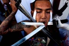 A devotee of the Chinese shrine of Kathu Shrine pierces his cheeks with swords during a procession on October 4. (Athit Perawongmetha/Getty Images)