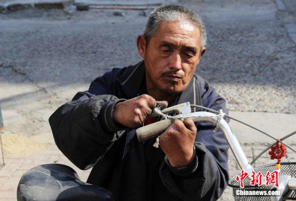 Yue Jin bike repairman3 600x407 - Лишенный пальцев мужчина смог стать профессиональным мастером по ремонту велосипедов